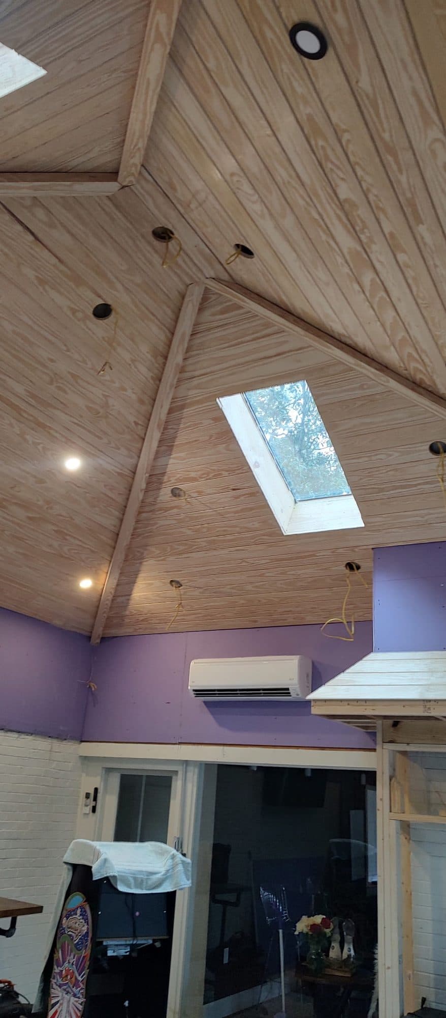 Vaulted tongue-and-groove pine ceiling with a skylight and recessed lights